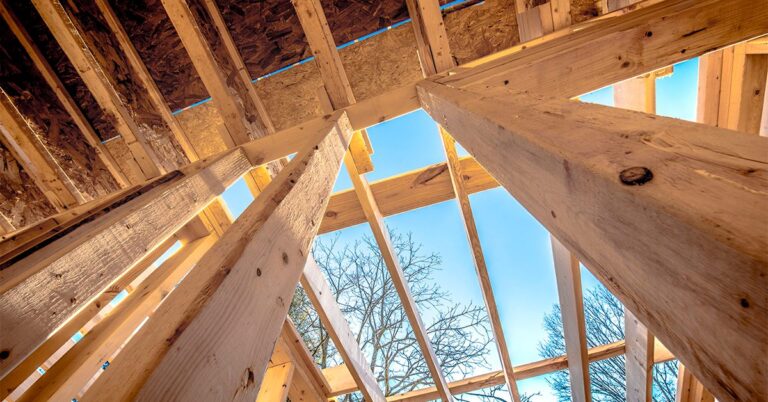 looking up through house framing to blue sky and bare trees gettyimages 900622122 1200w 628h